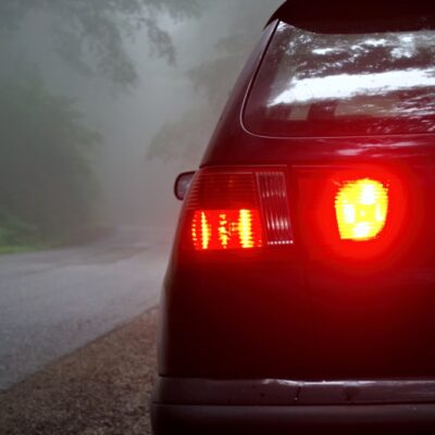 auto na ceste z rozsvietenou hmlovkou vzadu