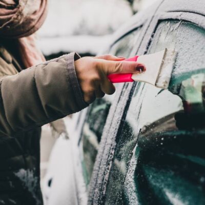 Škrabka v ruke zamrznuté okno auta