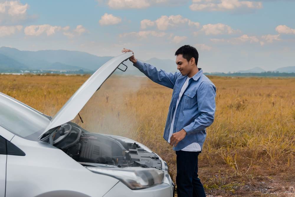Vodič a auto s otvorenou kapotou