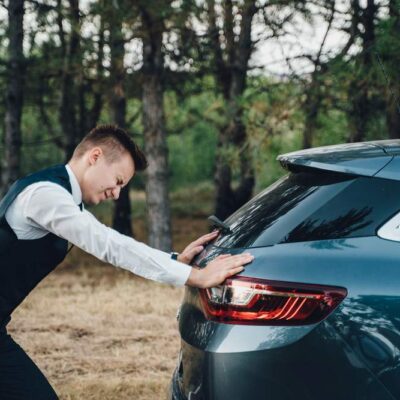 Mladý vodič tlačí auto