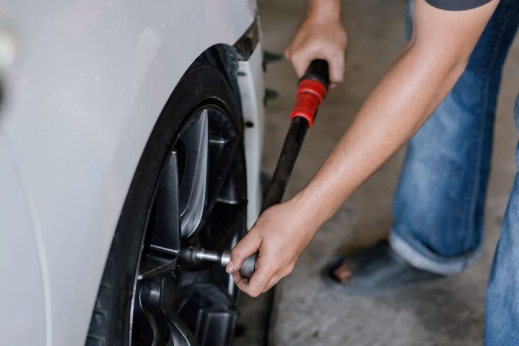 Chlap doťahuje skrutku kolesa