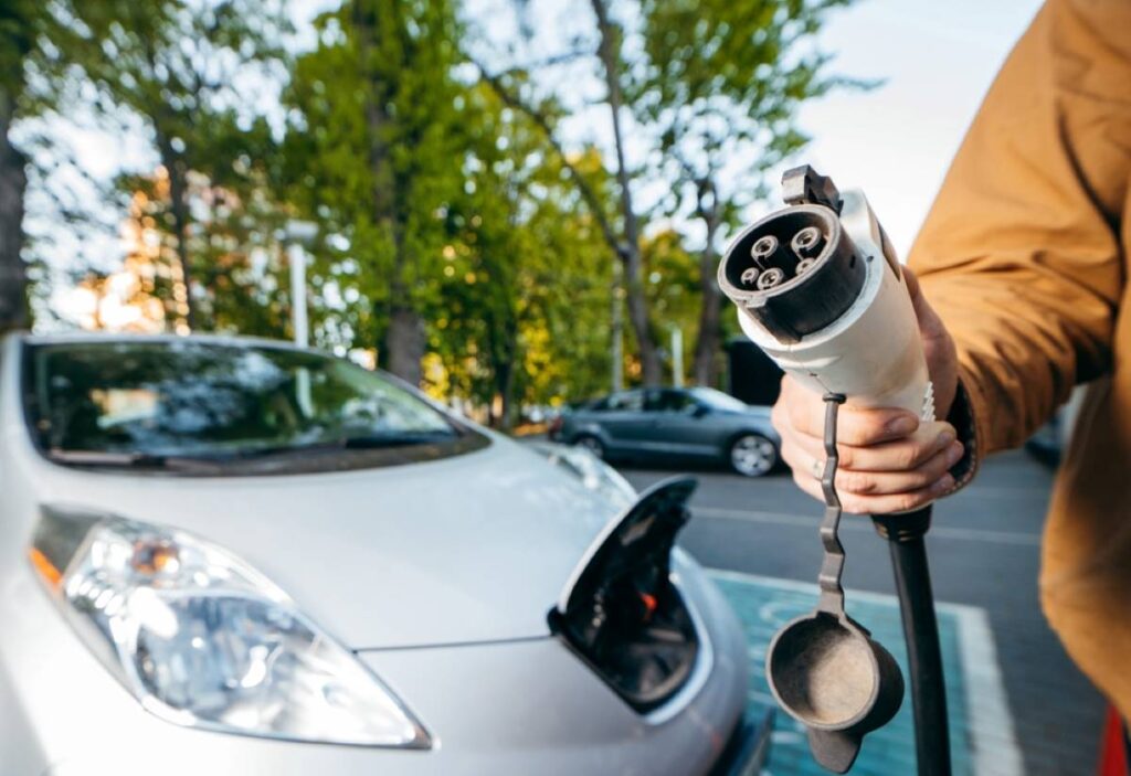 V ruke kábel na nabíjanie elektromobilu