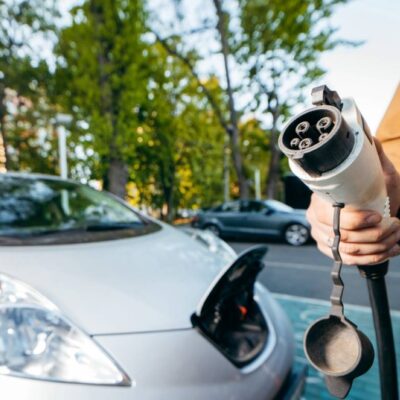 V ruke kábel na nabíjanie elektromobilu