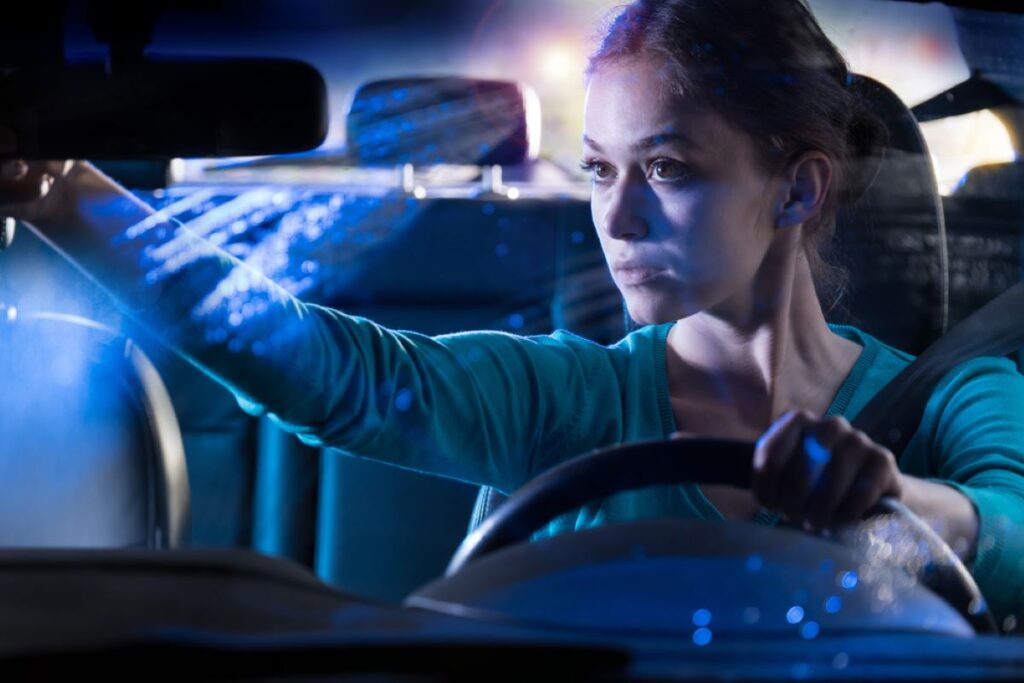 Žena nastavuje spätné zrkadlo v noci