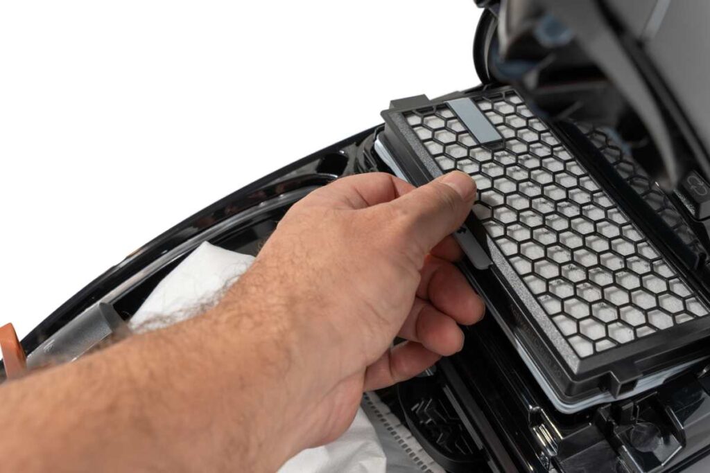 Detail kabínového filtra v BMW i5 s varovným štítkom o recall