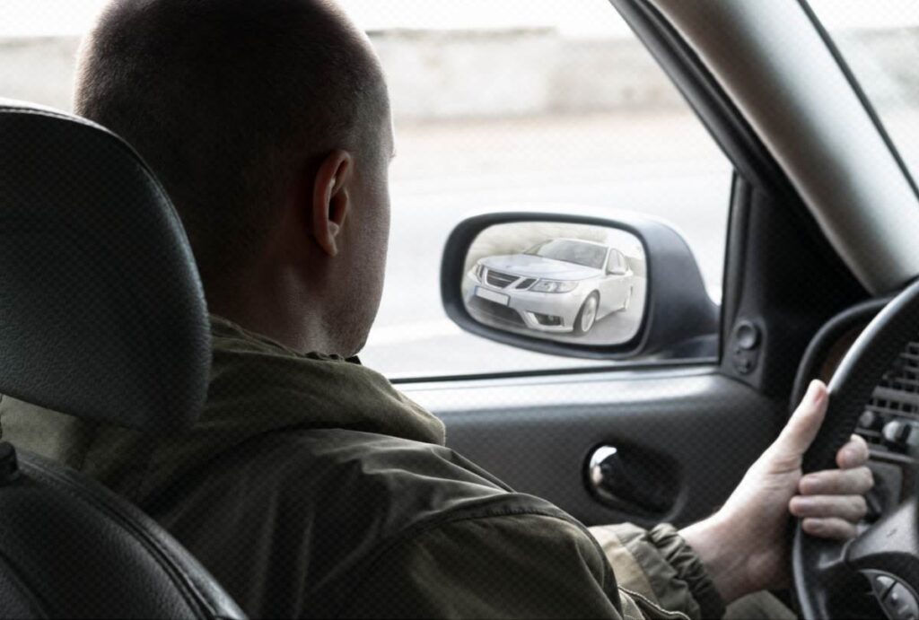 Vodič kontroluje nastavenie ľavého bočného zrkadla naklonením hlavy k oknu.