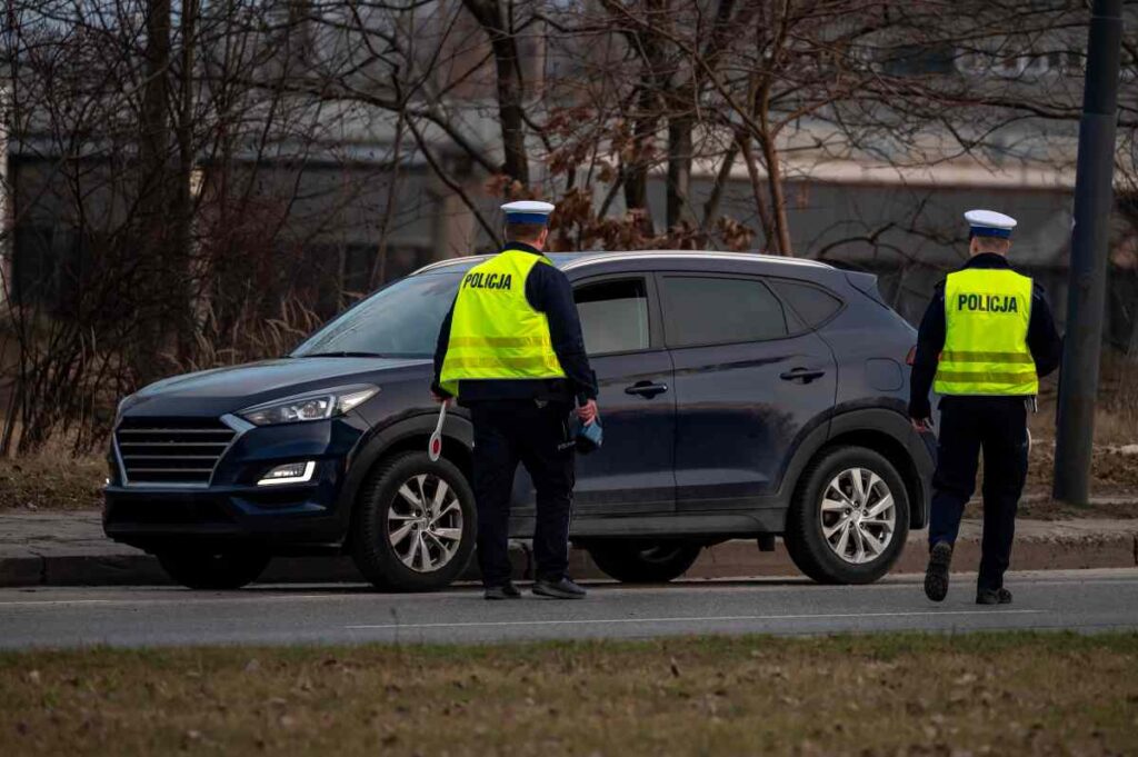 Policajt v reflexnej veste prikladá digitálny luxmeter