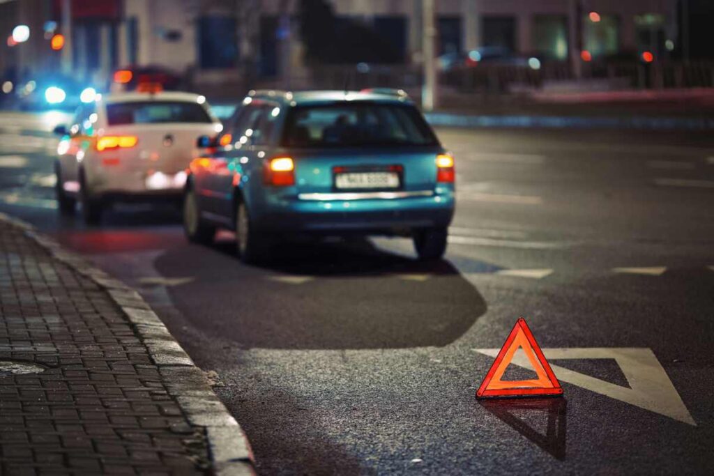 Vodič zapína výstražné svetlá po zastavení auta pri krajnici