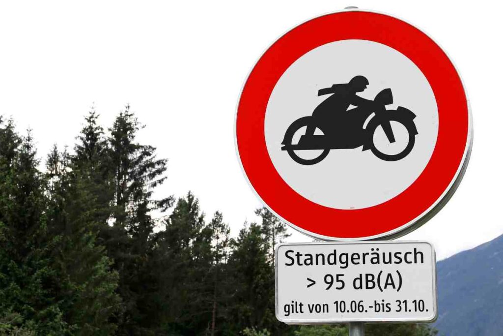 Rakúska dopravná značka upozorňuje motocyklistov na zákaz vjazdu pre stroje s hlukom nad 95 dB(A).